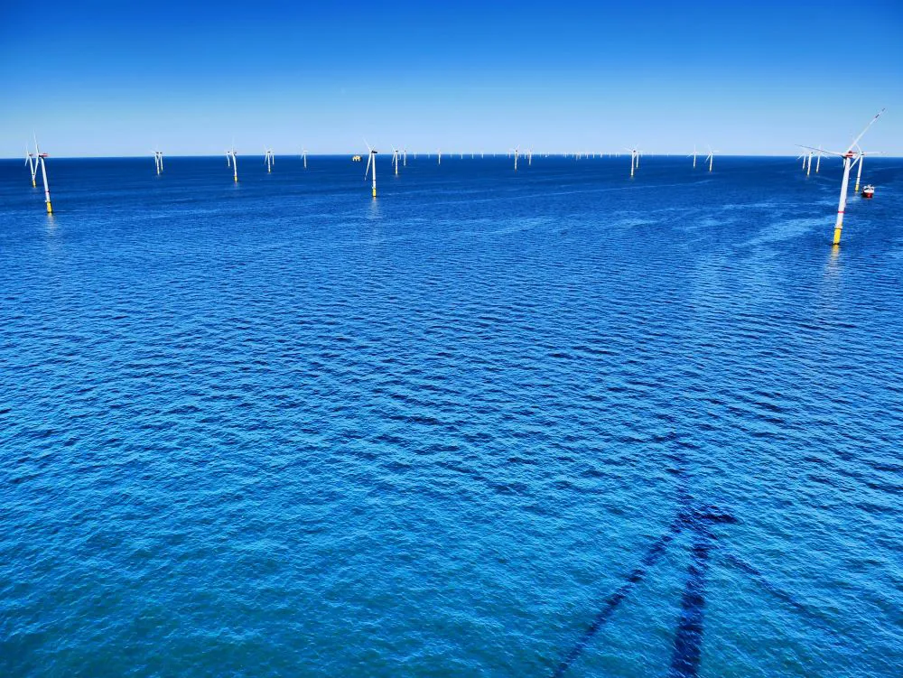Offshore wind turbines in deep blue water.