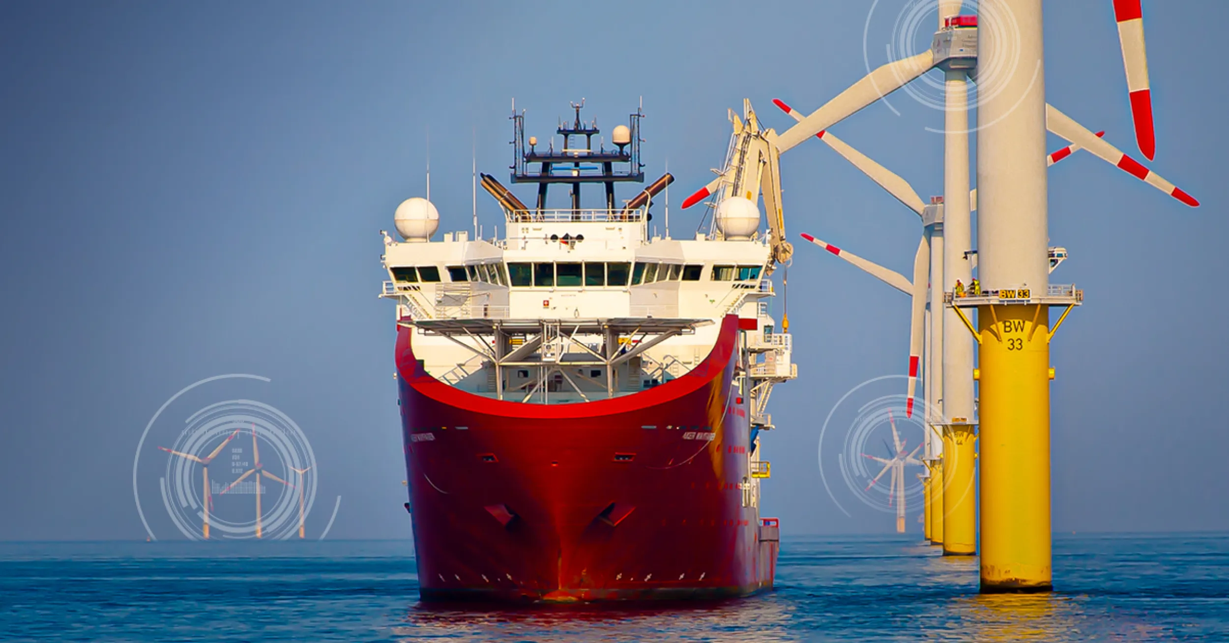 Red ship near offshore wind turbines.