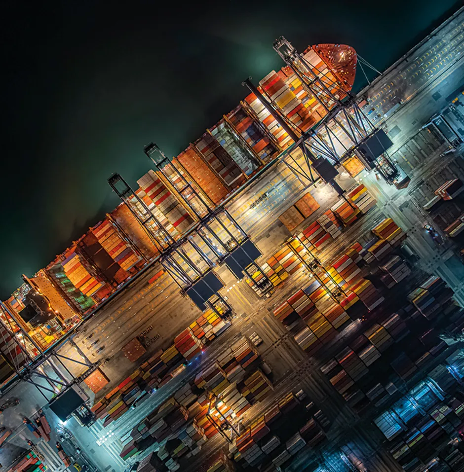 Aerial view of a port crane loading containers onto a ship