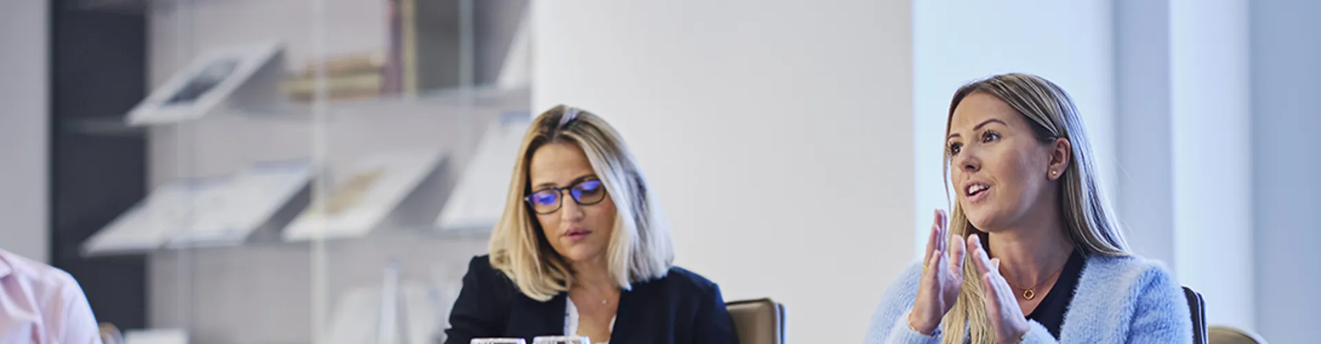woman talking in a meeting with two other colleagues