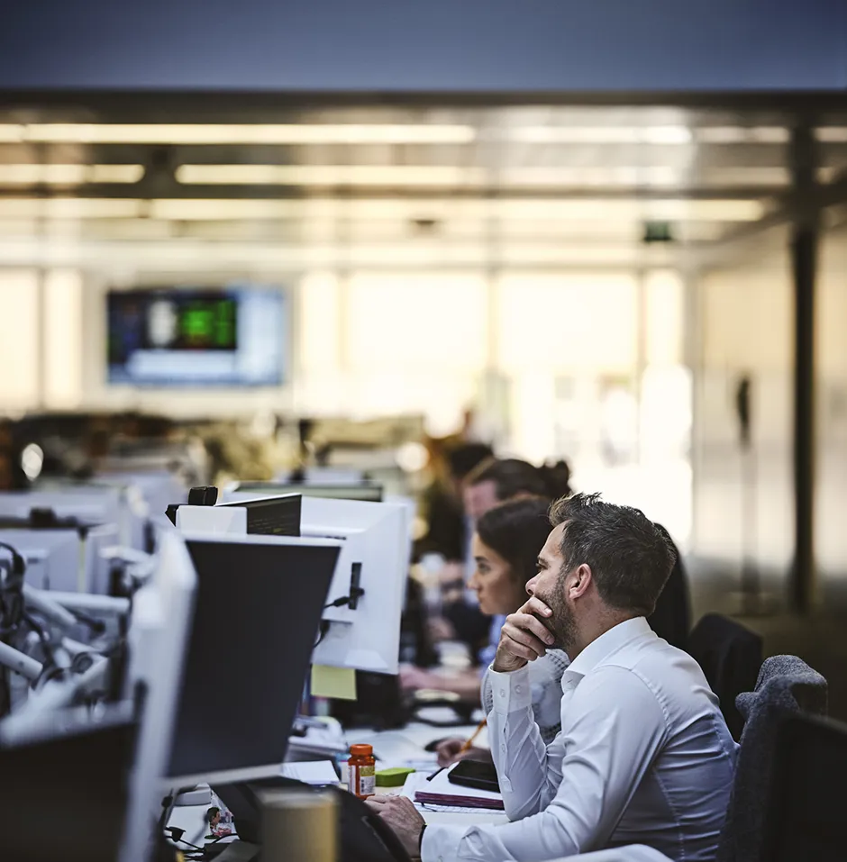 Office workers focused at their desks with computers.
