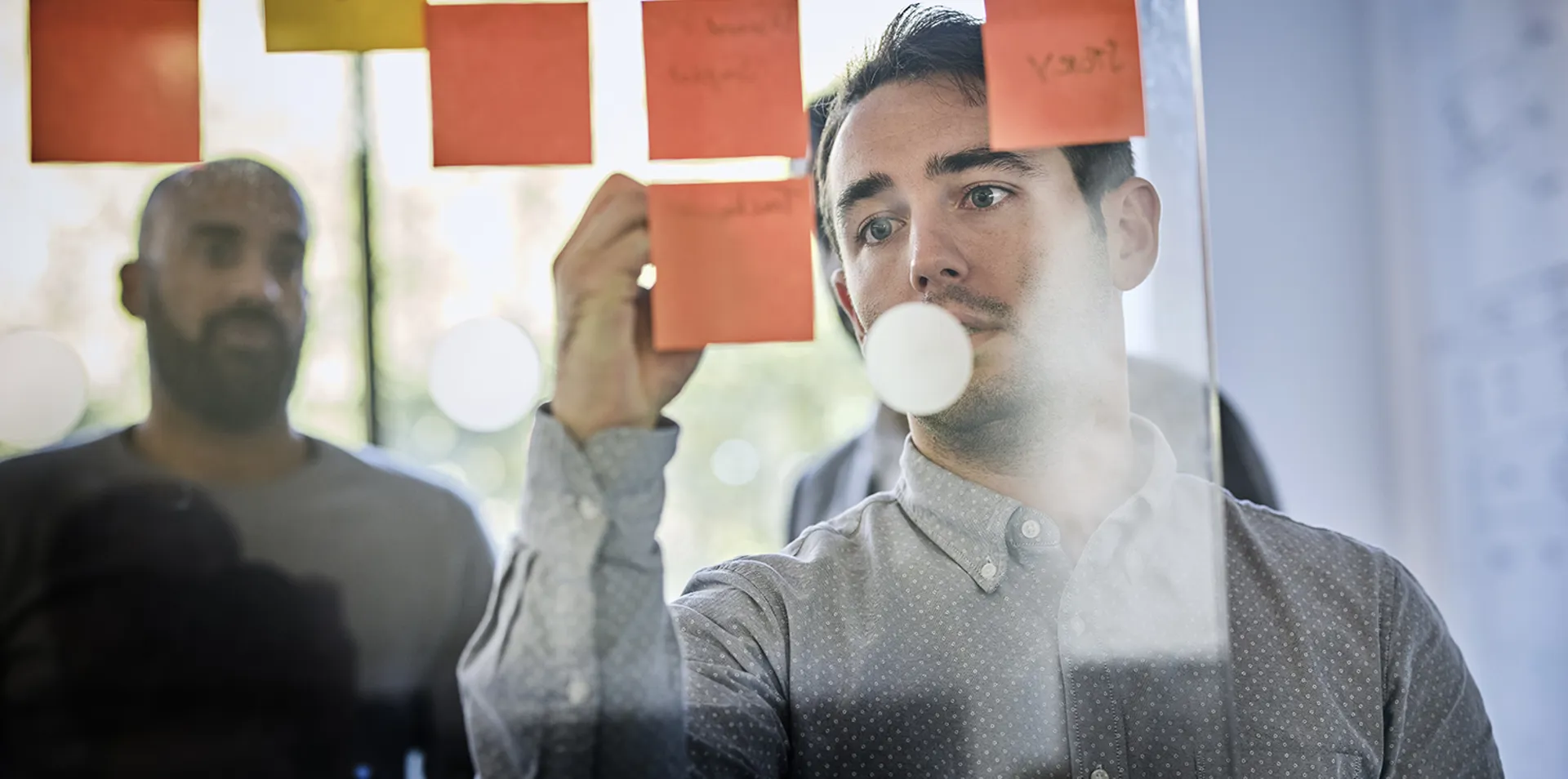 close up of man writing notes on the wall in a meeting