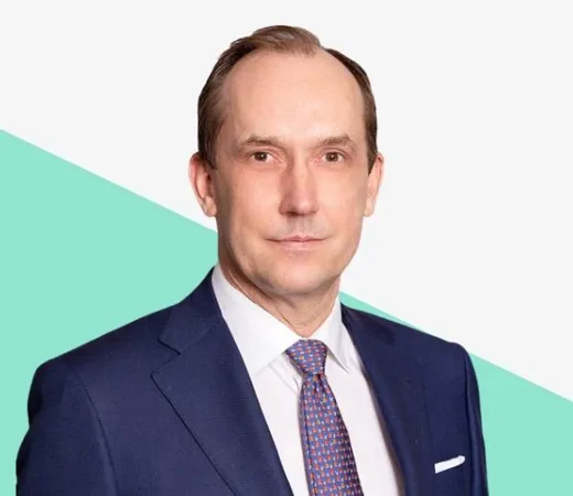 A man in a suit against a colorful background.