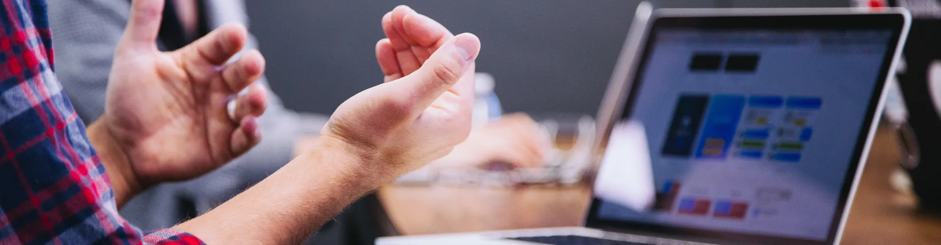 close up of mans hands gesturing at laptop screen