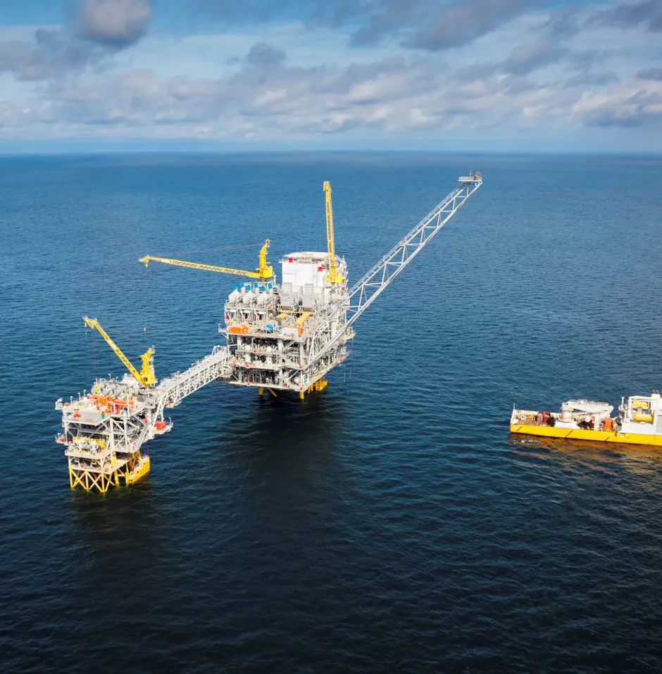 Offshore oil platform with supply vessel nearby.