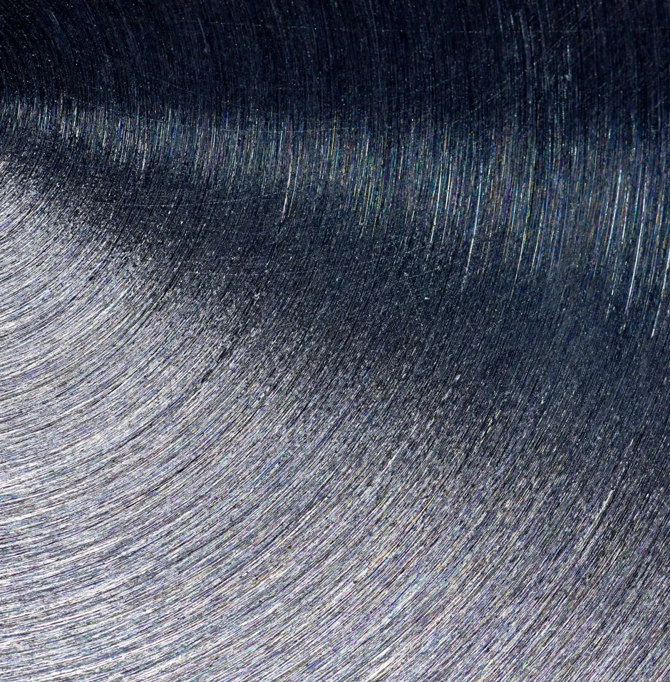 Close-up of a brushed metal surface with a fine circular pattern