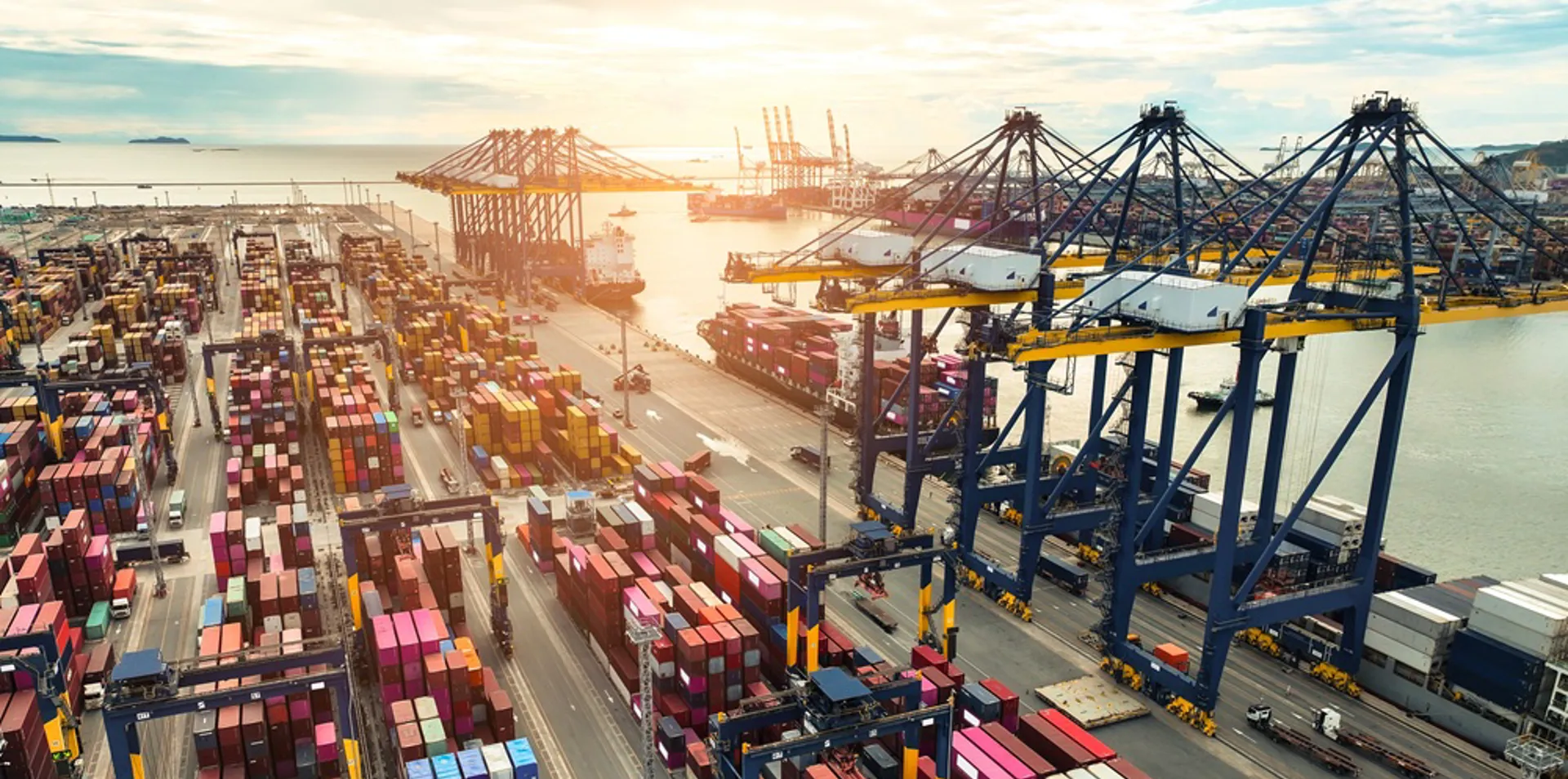 Container ship berthed at a container terminal with cargo trucks on the quayside