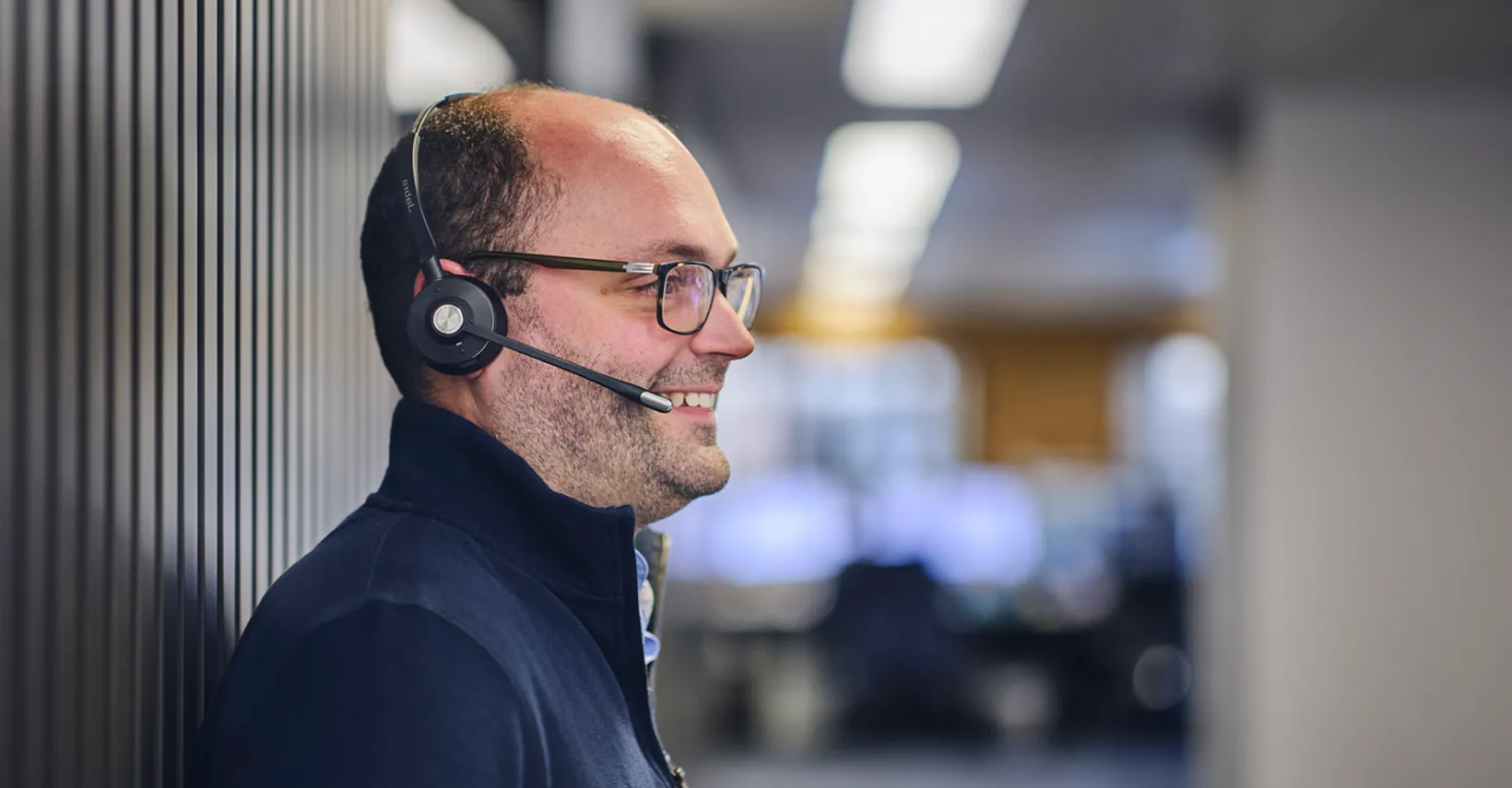 Smiling man with headset in office environment