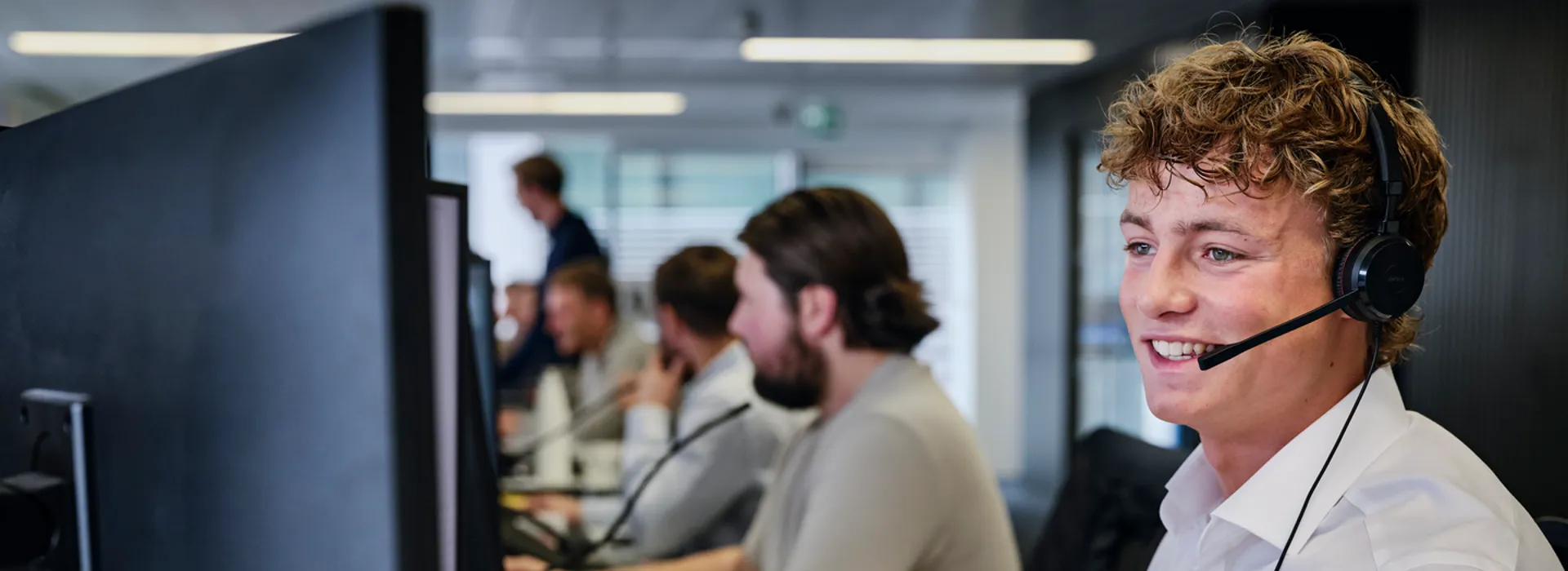 Smiling man with headset at office desk