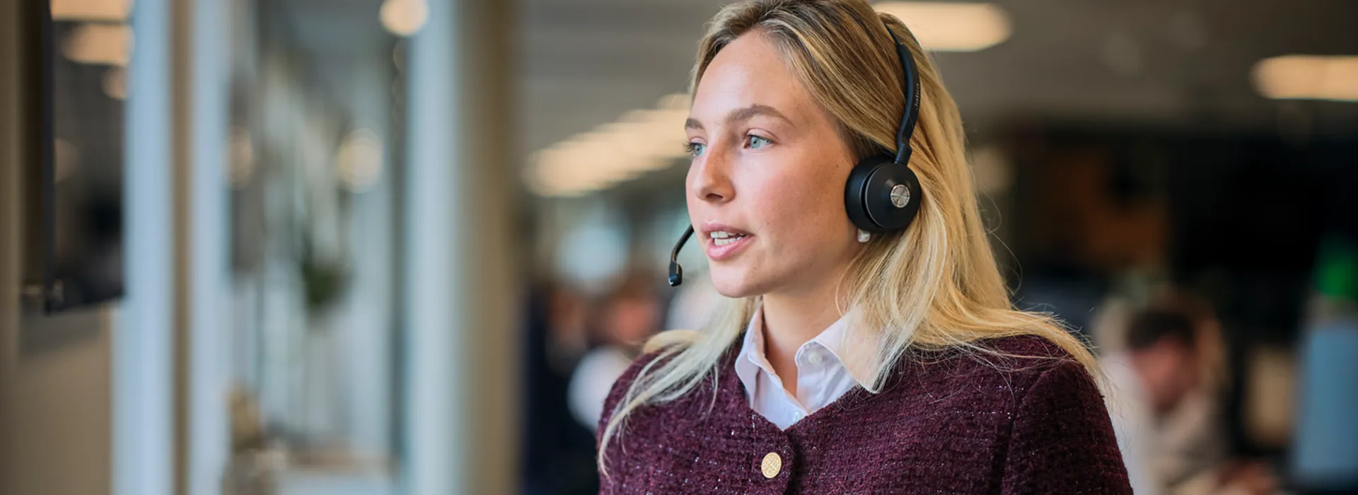 Woman with headset speaking in office environment