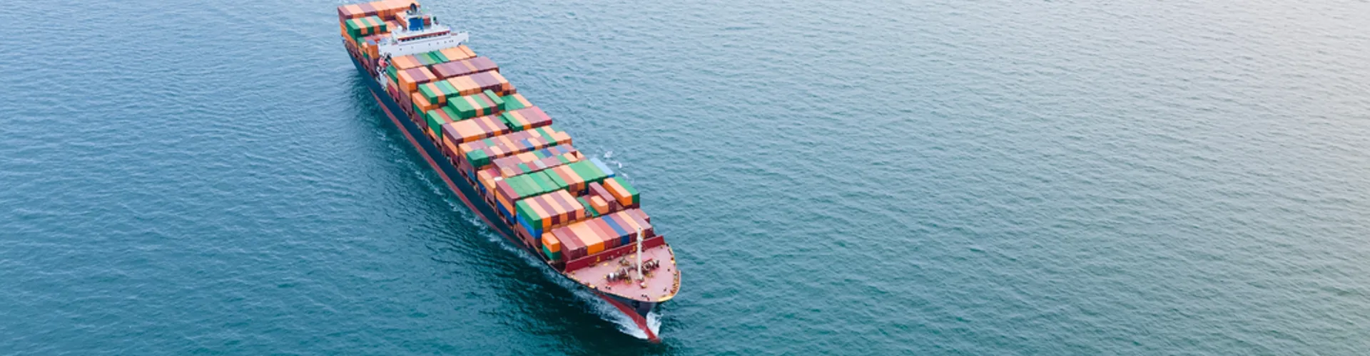 Cargo ship loaded with colourful containers, aerial view