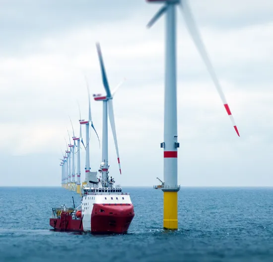 Offshore wind turbines with a maintenance ship.